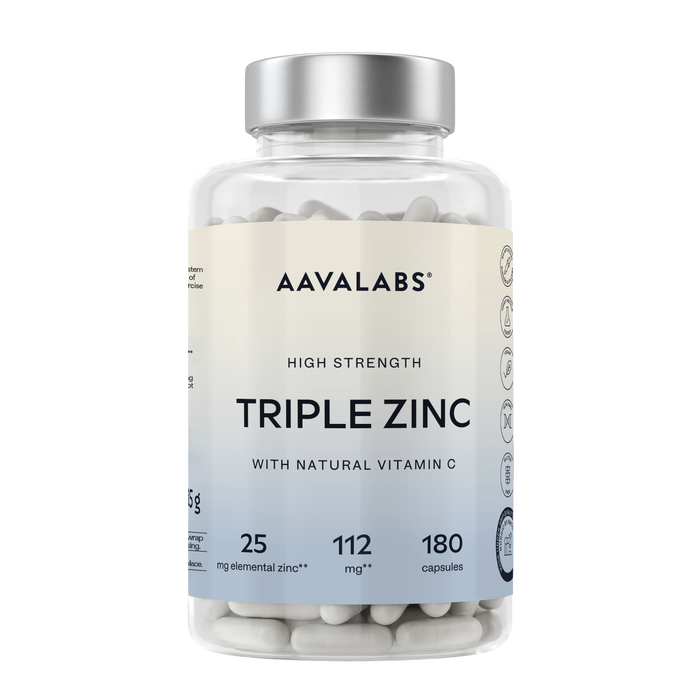 A clear plastic bottle of Aavalabs Triple Zinc supplement with a silver cap and a cream-to-light-blue label, filled with white capsules, on a white background.